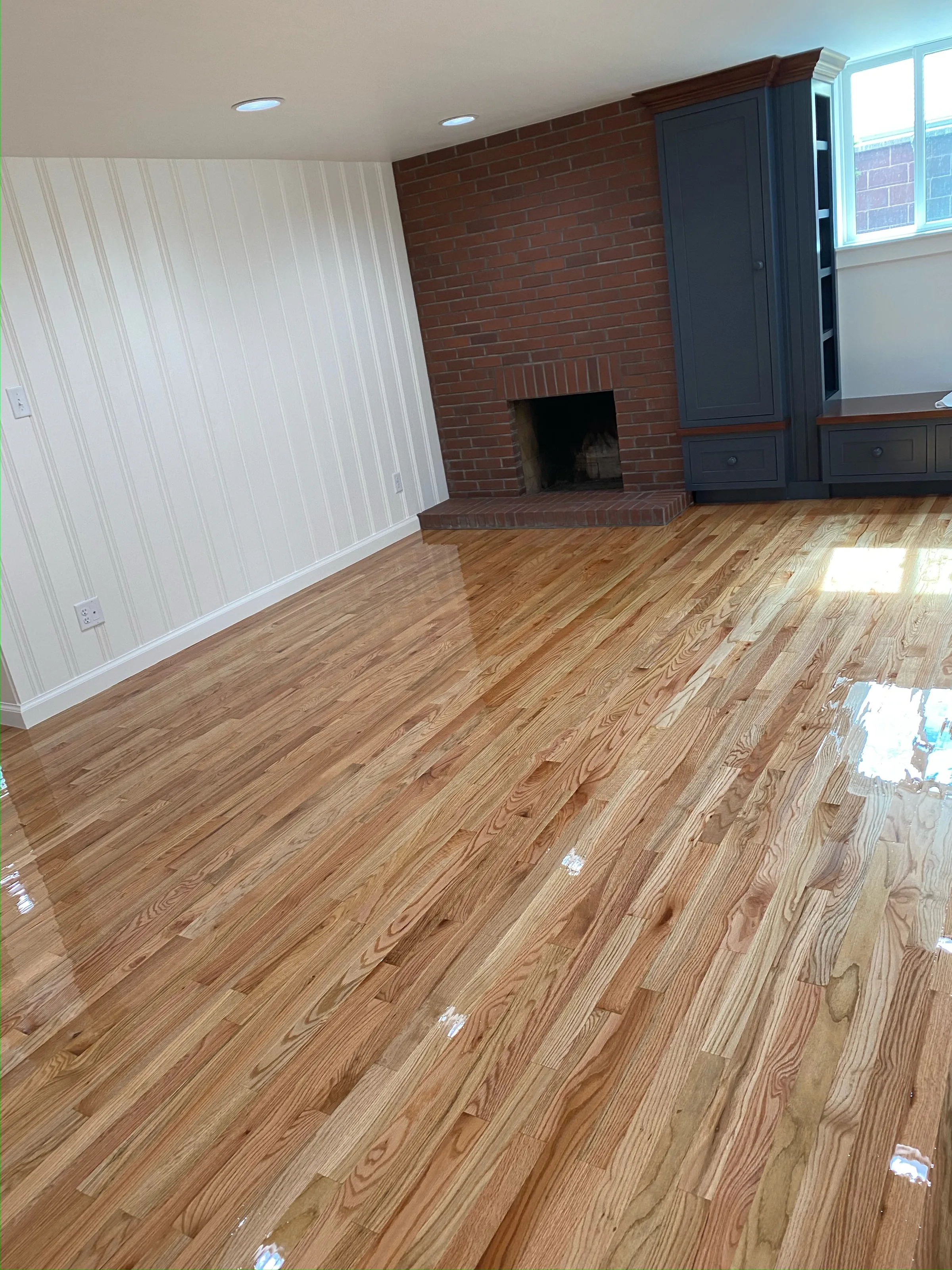 Warmly finished red oak hardwood flooring with natural grain variation and satin sheen in a bright entryway space.