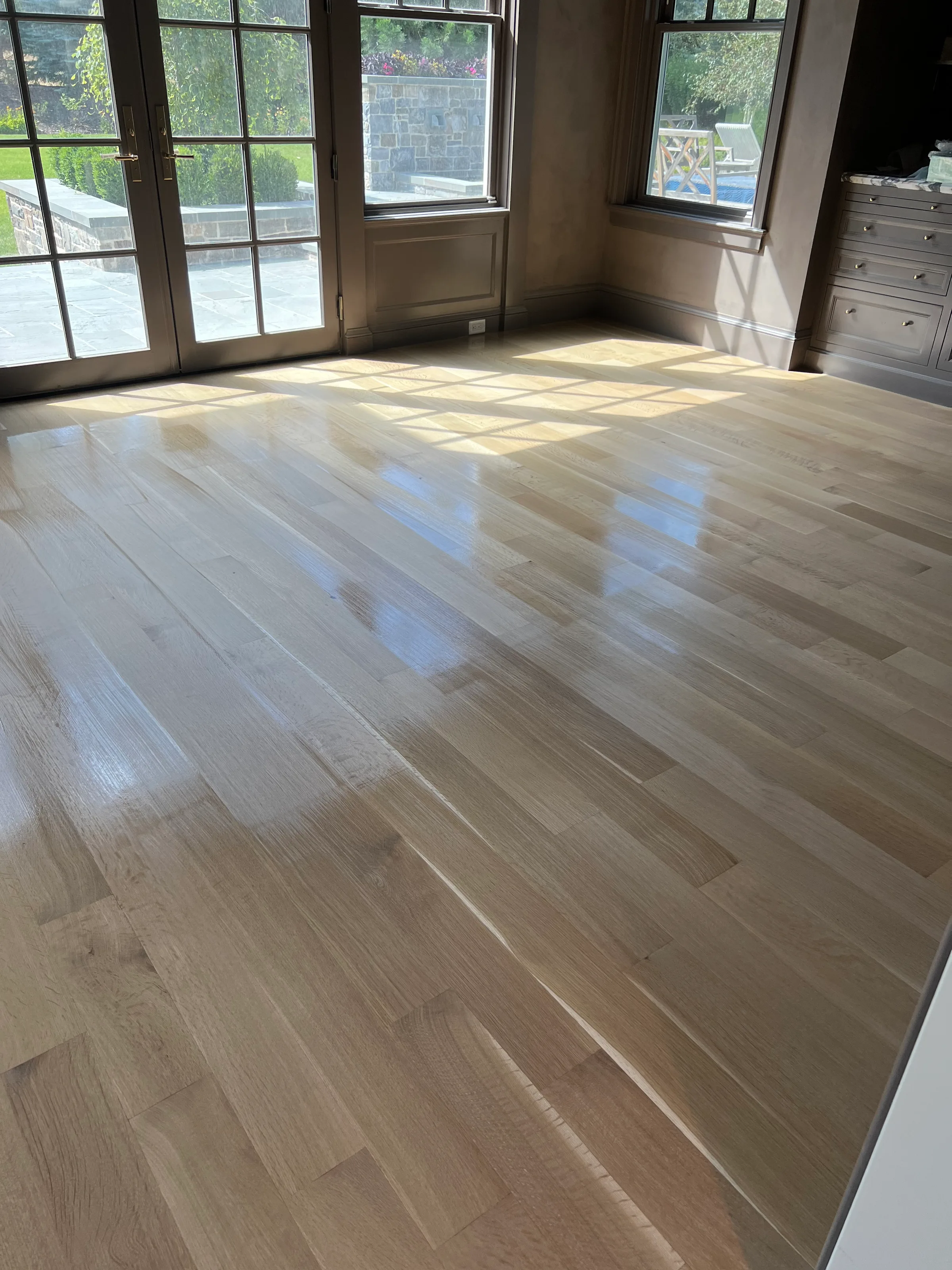 Refinished white oak flooring revealing rich grain and depth with glossy protective finish