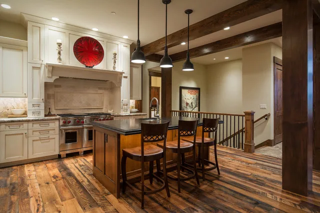 Reclaimed oak flooring with striking grain and color variation in a kitchen and dining area with exposed beams