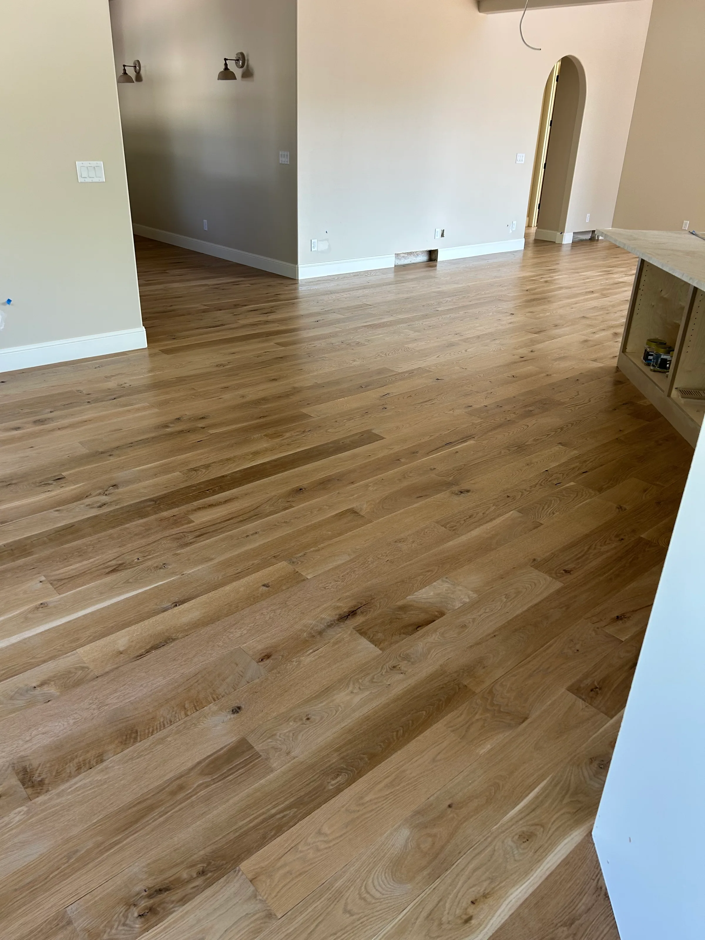 Newly installed white oak hardwood flooring with light natural finish in bright modern kitchen