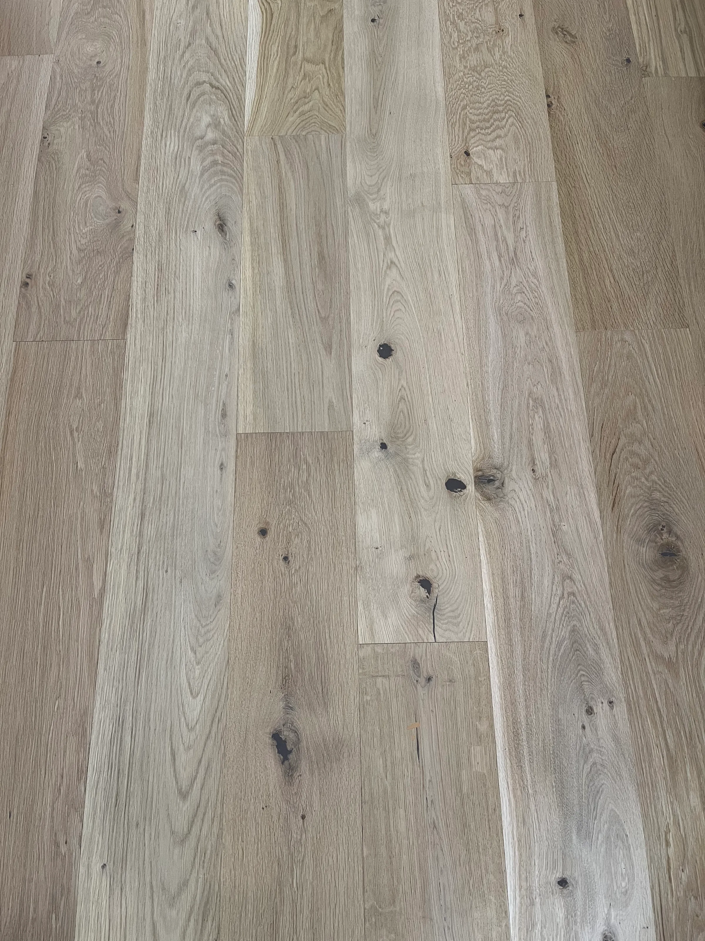 New white oak hardwood flooring with natural color variation and grain visible in bright interior