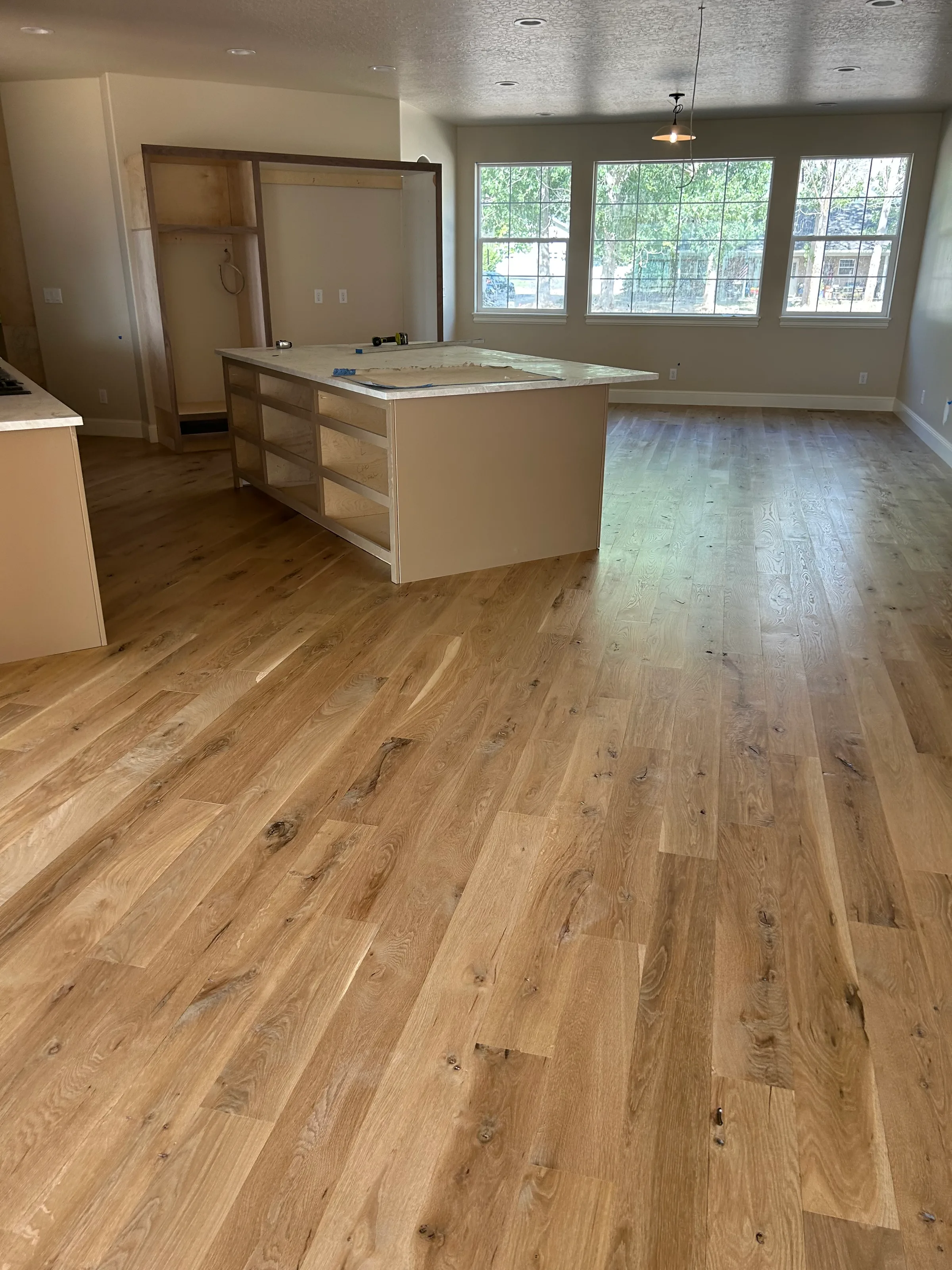 Light white oak flooring with visible grain patterns illuminated by natural skylight in residential interior