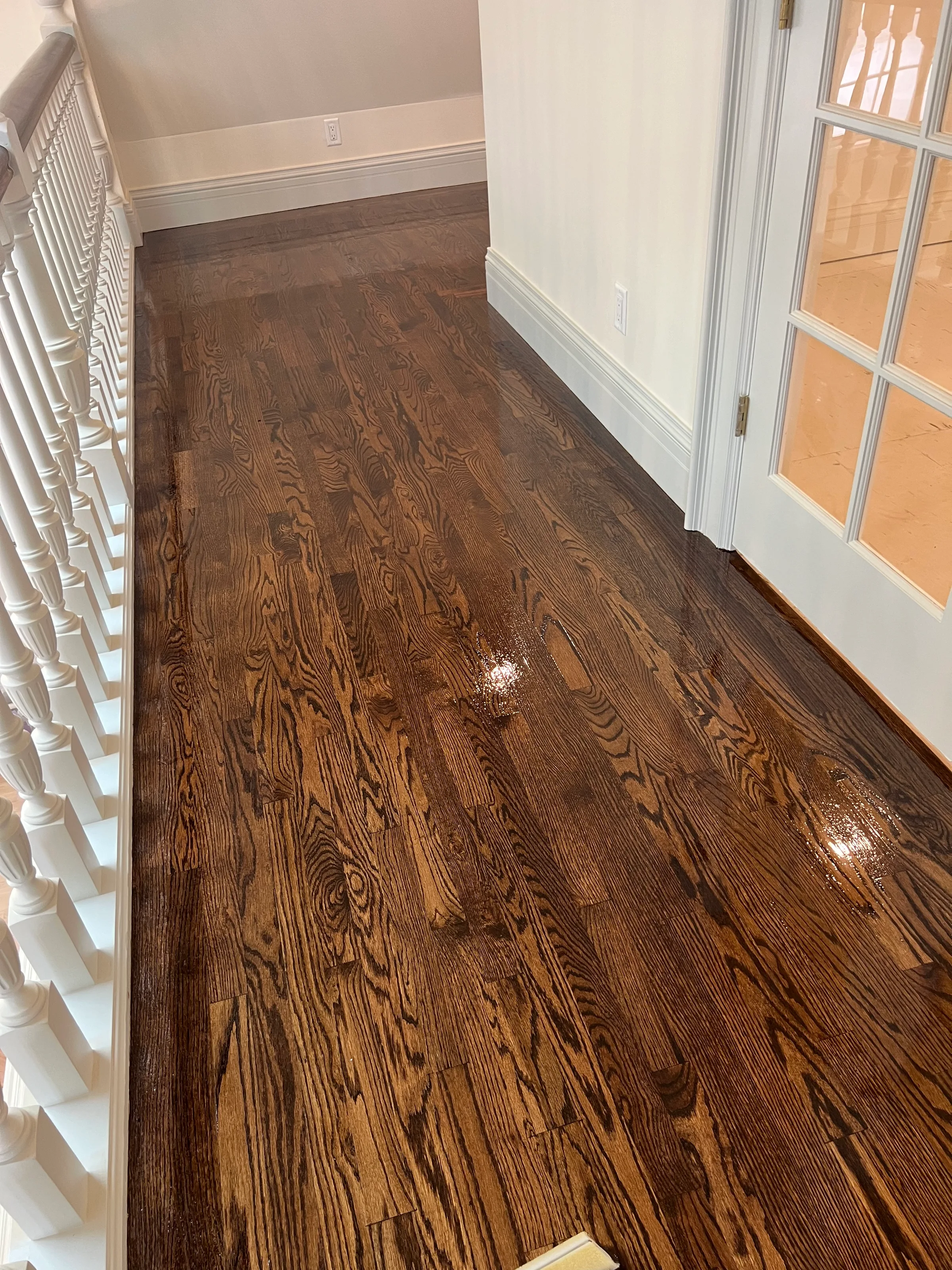 Newly installed red oak flooring with distinct grain patterns in bright residential entry hall