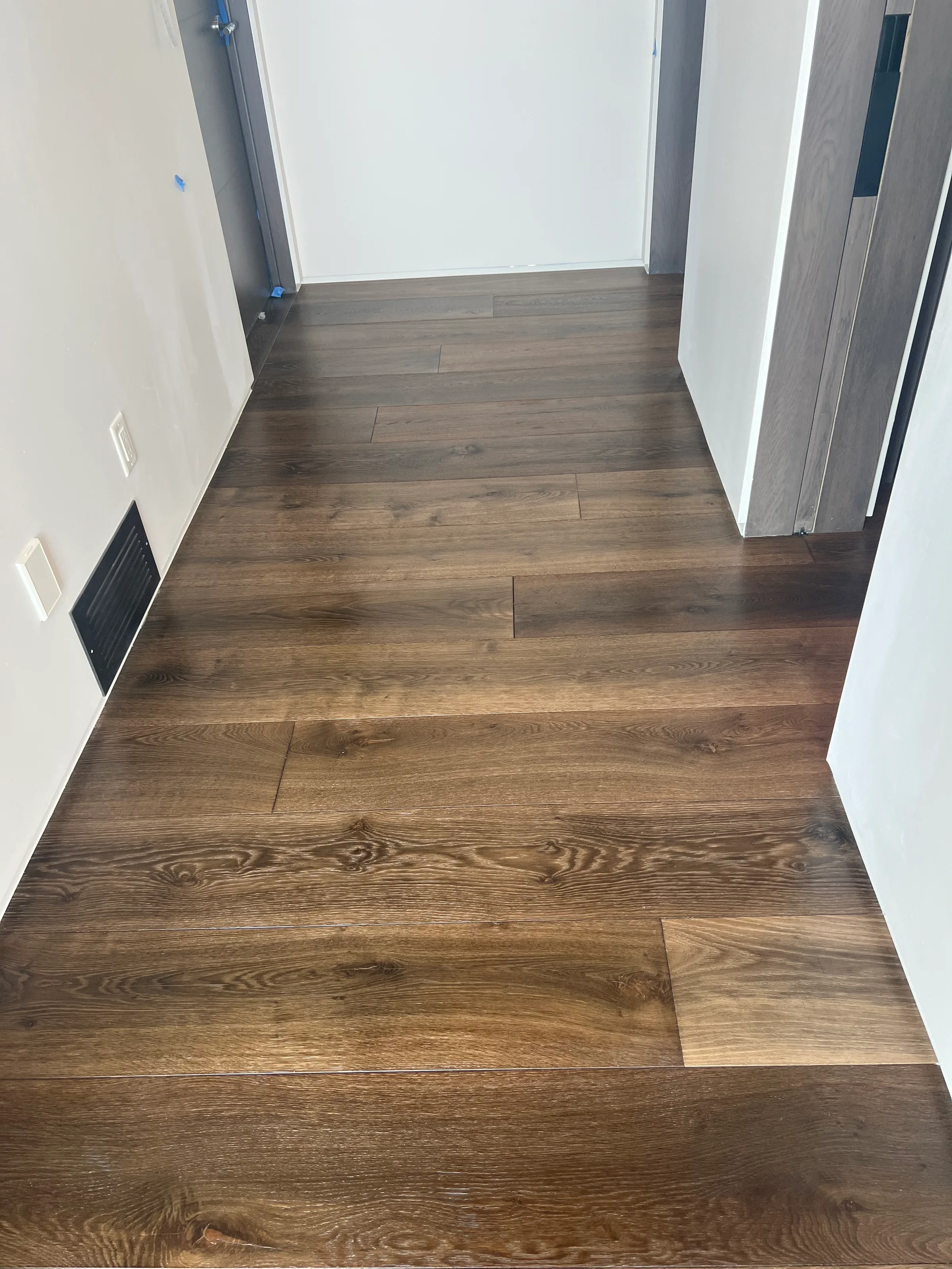 Pre-finished white oak hardwood with factory finish and subtle grain variation in well-lit residential space