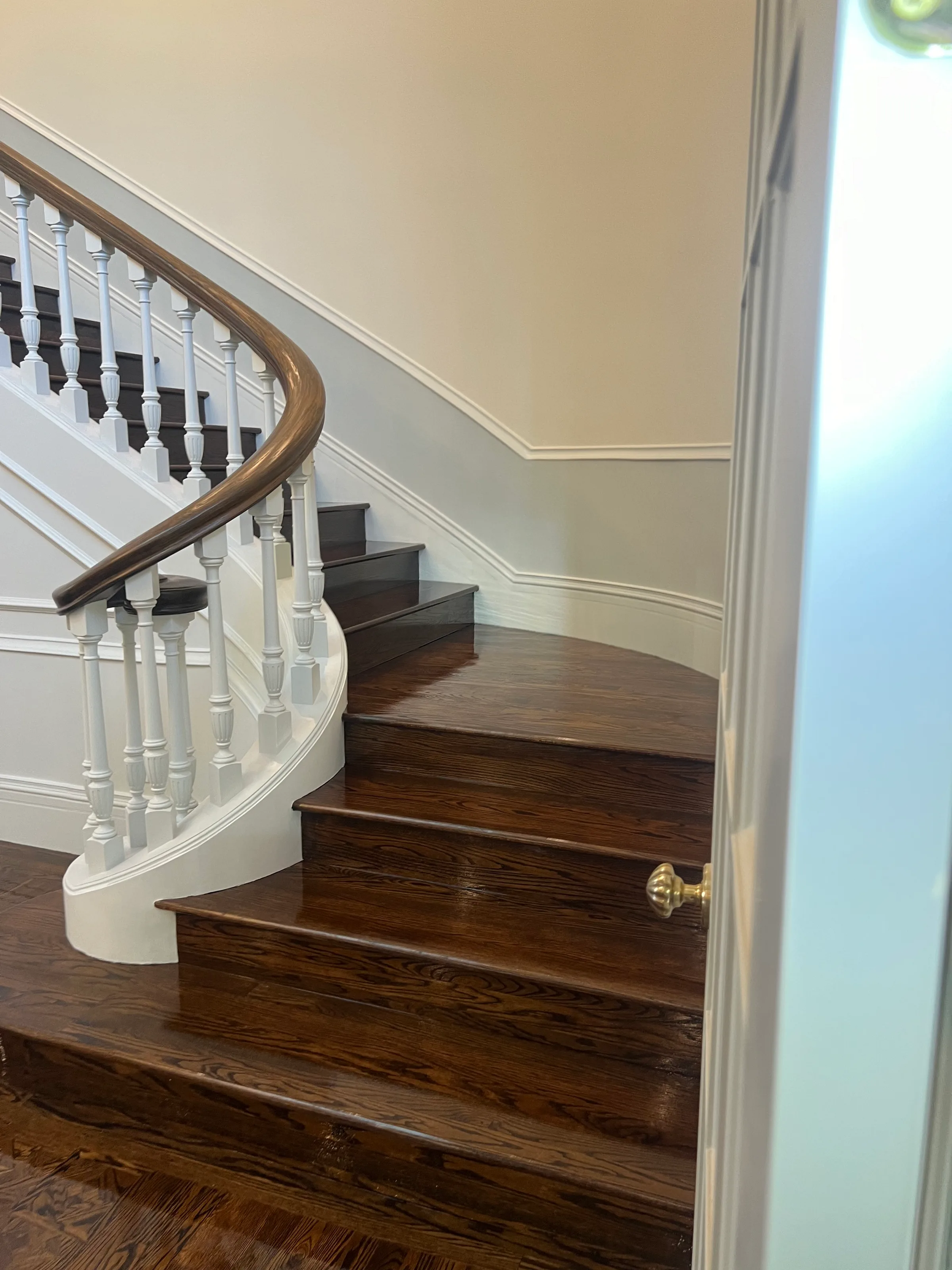 Red oak staircase with standard round tread profile and natural wood color in bright residential stairs