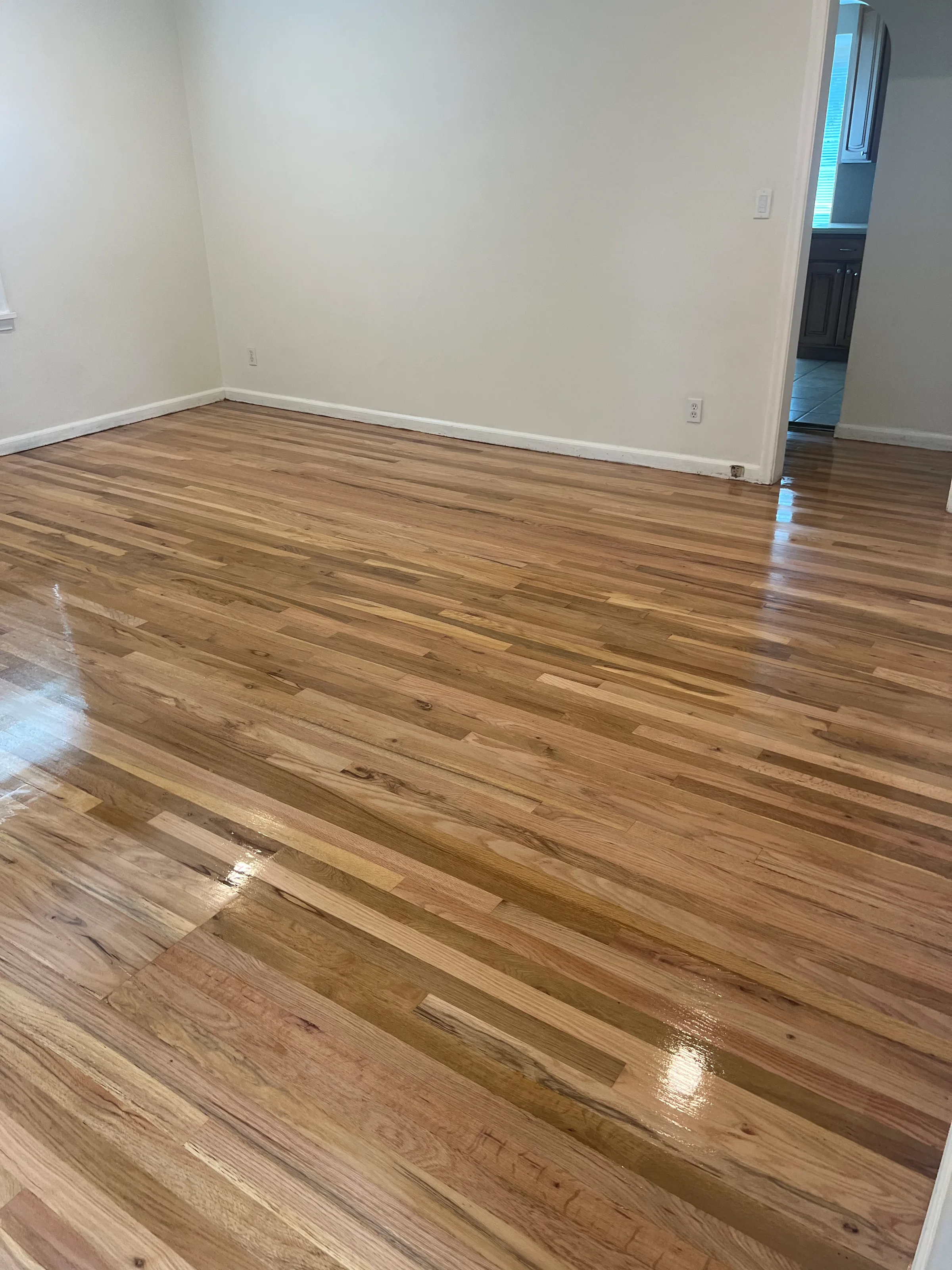 Refinished red oak flooring displaying rich color and grain patterns in residential interior space