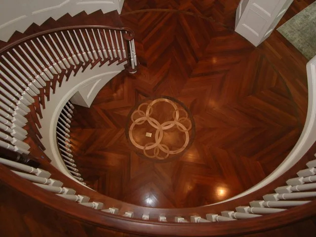 Installed cherry hardwood flooring with geometric parquet pattern in warm reddish tones