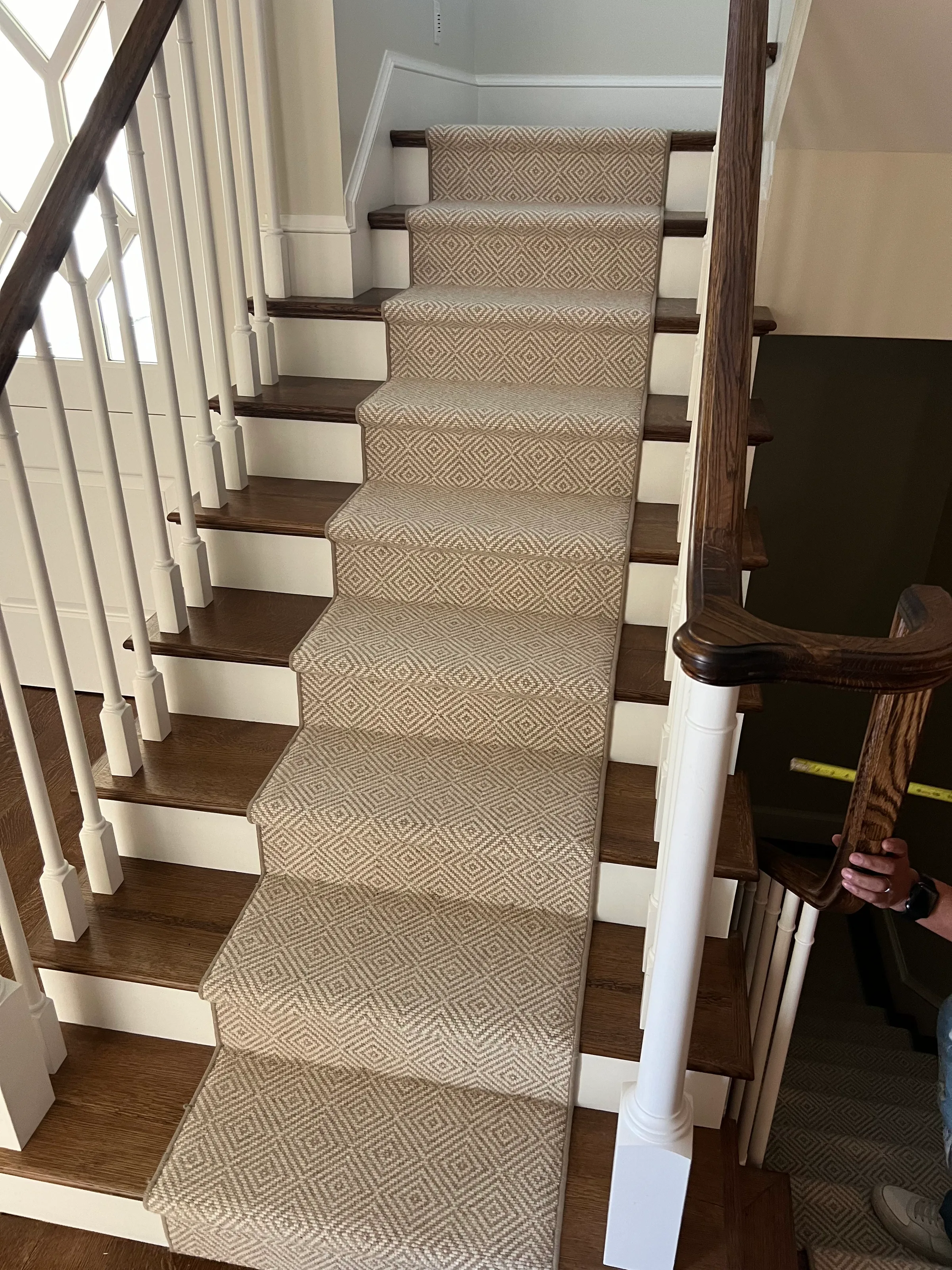 White oak curved staircase with standard round treads and white painted risers in residential entry
