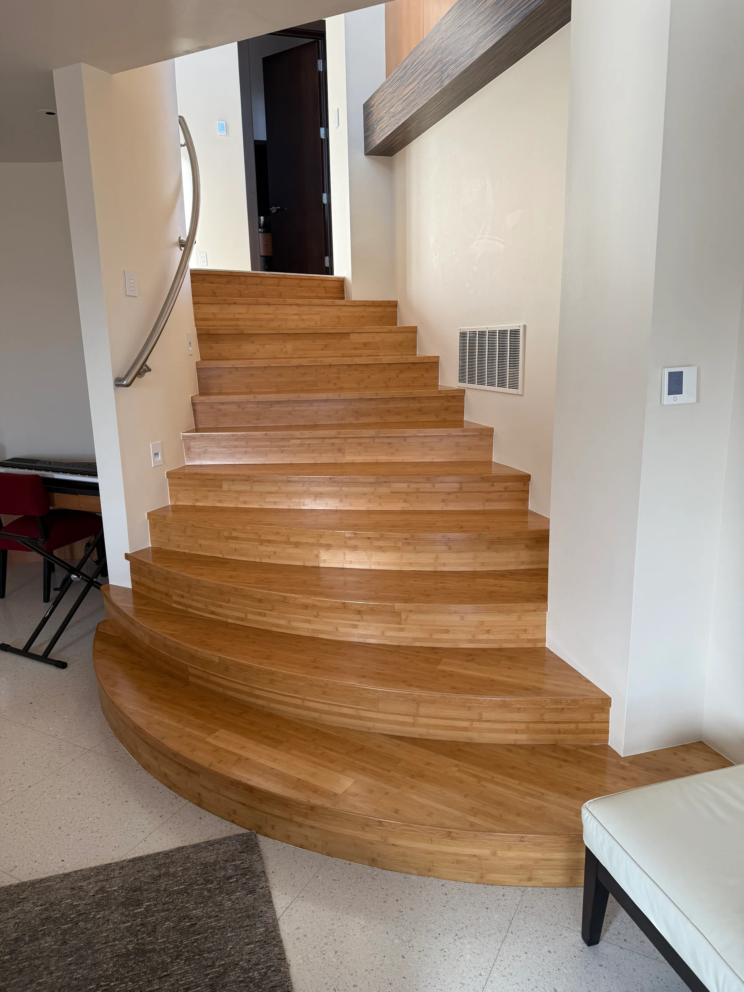 Bamboo stairs with squared treads and risers showing linear grain pattern in light-filled stairwell