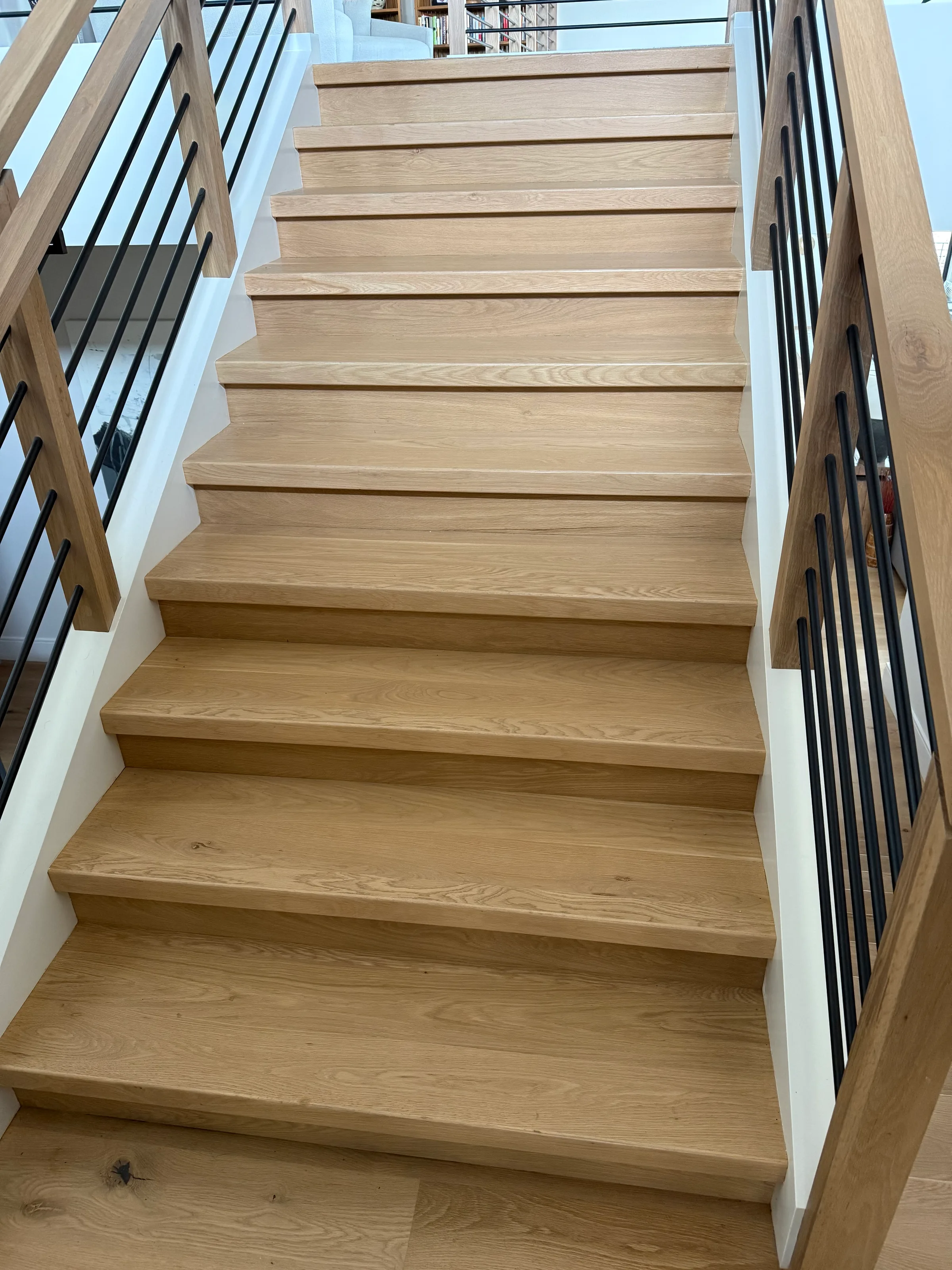 White oak custom squared staircase treads with natural grain visible in bright modern stairwell